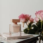 Sophisticated Narciso perfume bottle with pink roses and magazines. Perfect for elegance and fragrance themes.