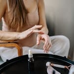 A woman indulges in self-care with skincare products and a jade roller at home.