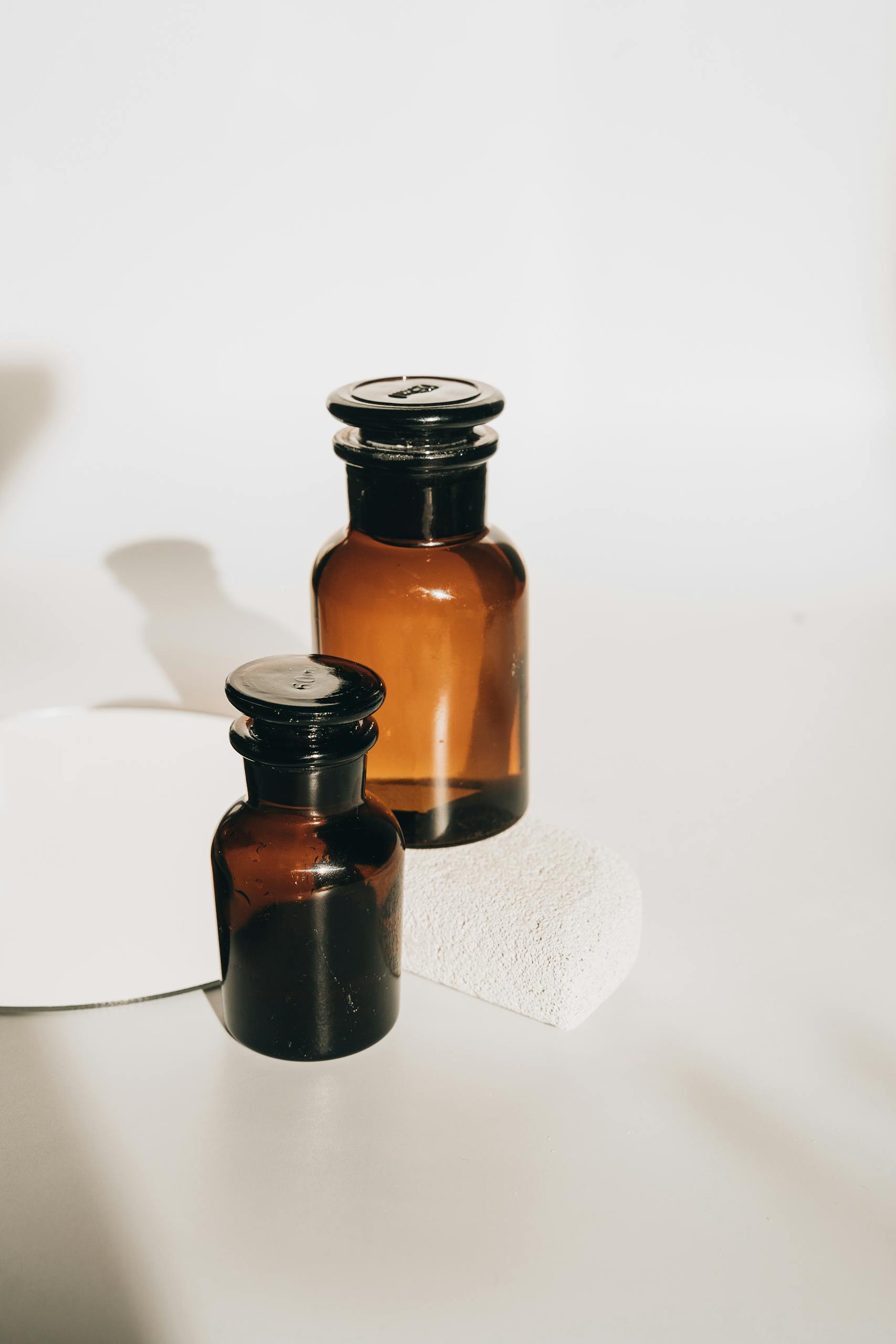 Stylish set of amber glass bottles with a minimalist touch, perfect for cosmetics or essential oils.